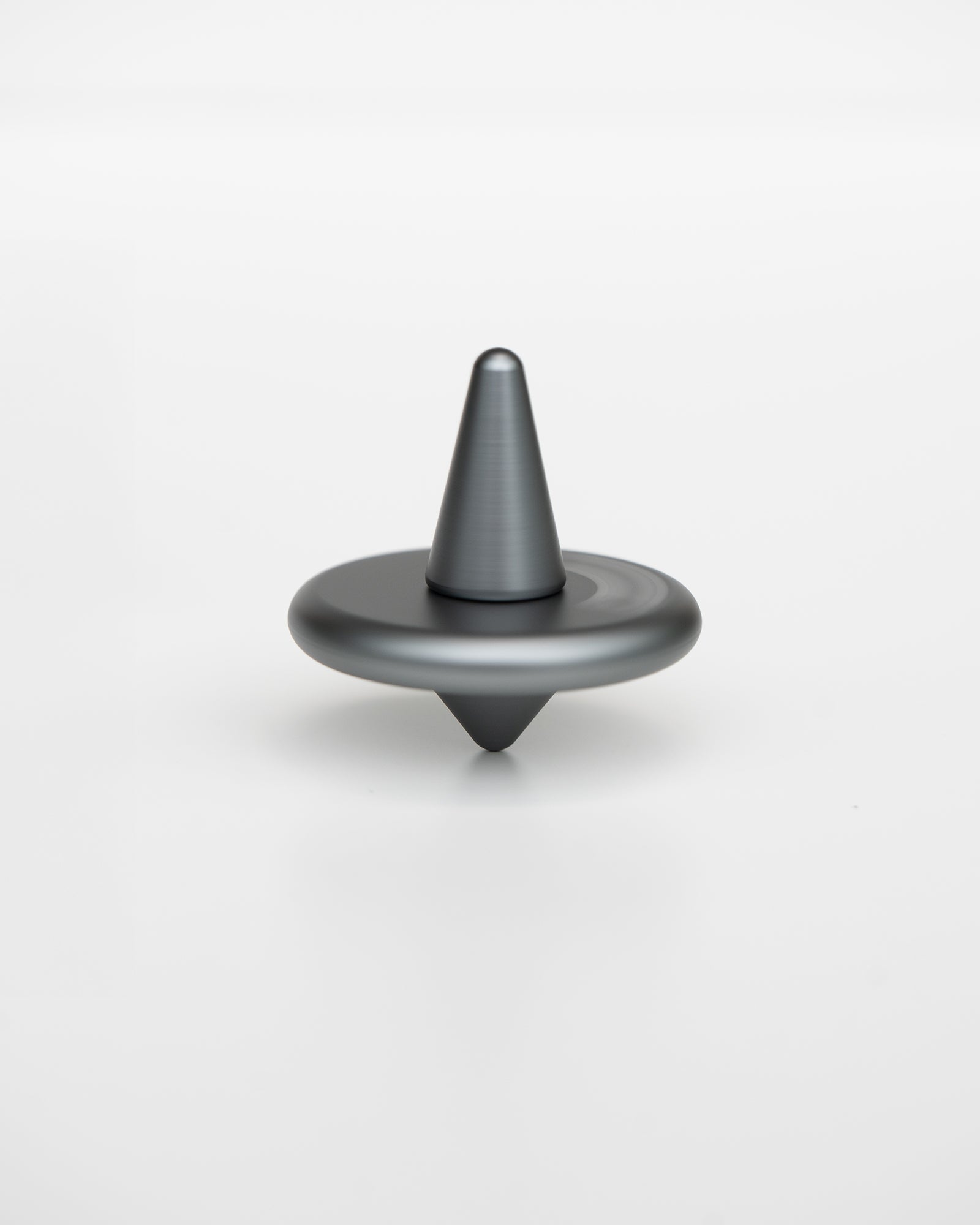 Close-up of the ST-01 spinning top spinning on a desk surface