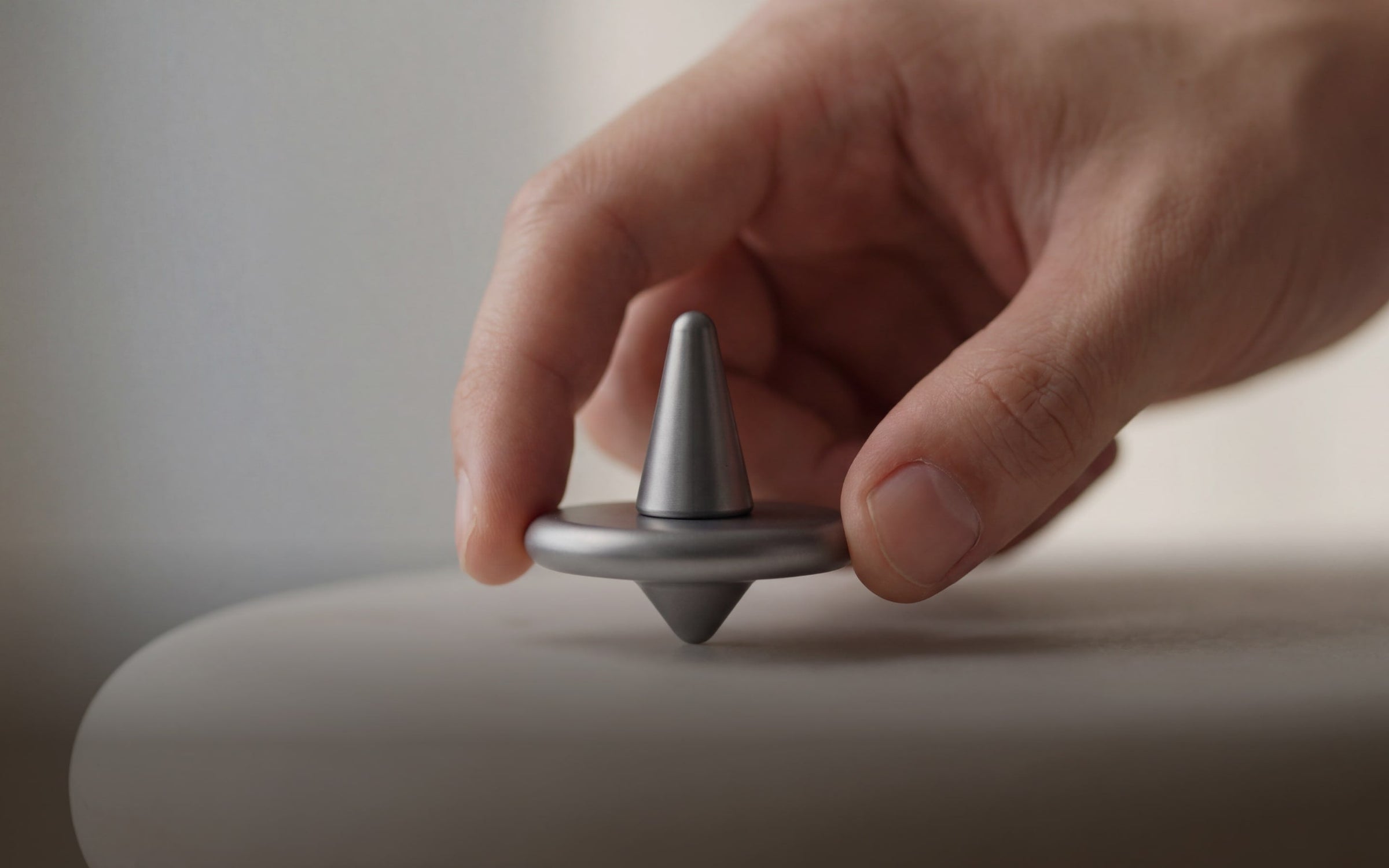 ST-01 spinning top on a desk, as a screen-free tactile object during work